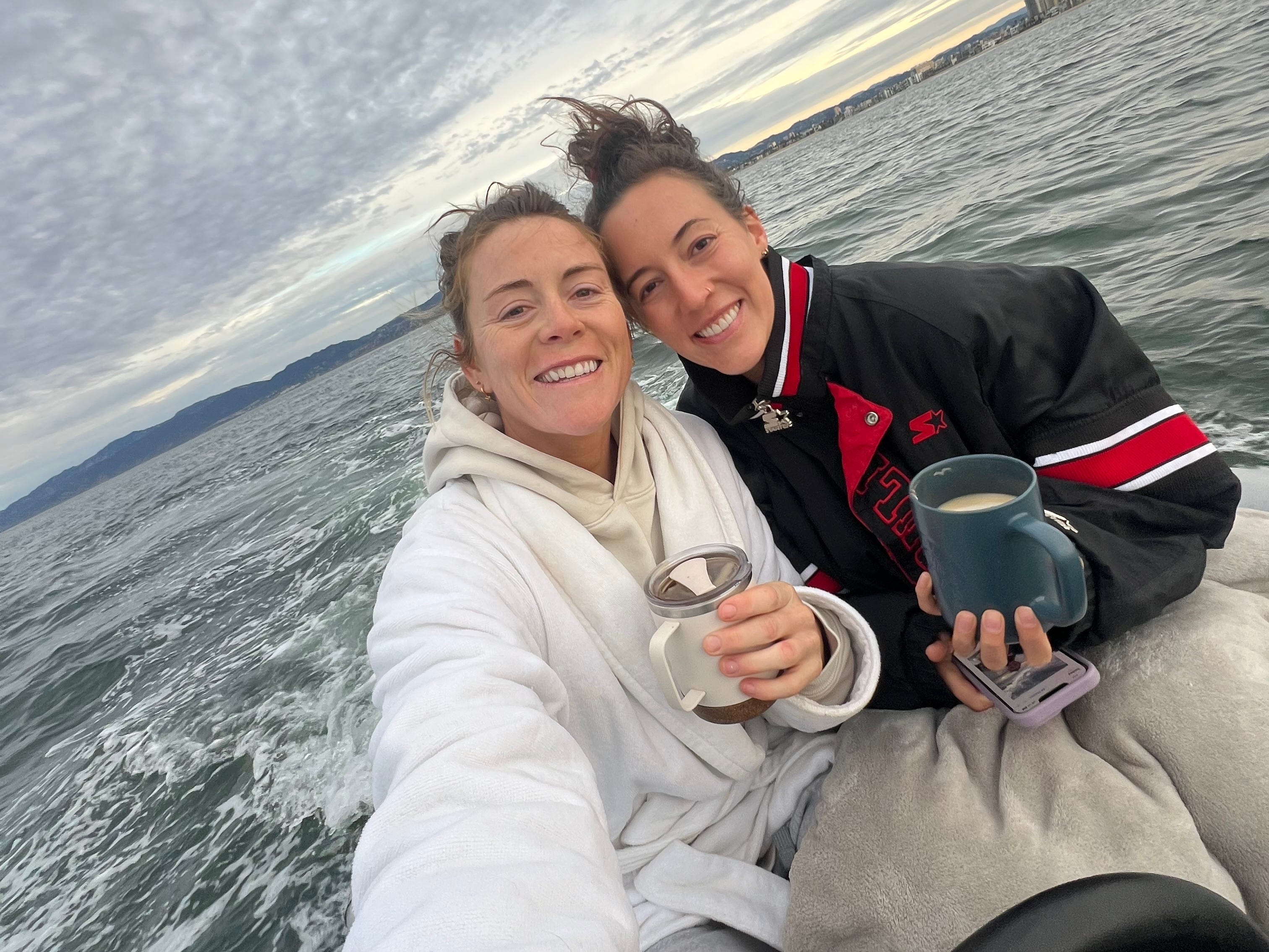 The author, right, and her girlfriend posing together on a dinghy.