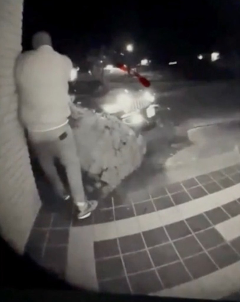 Suspect standing outside a building at night.