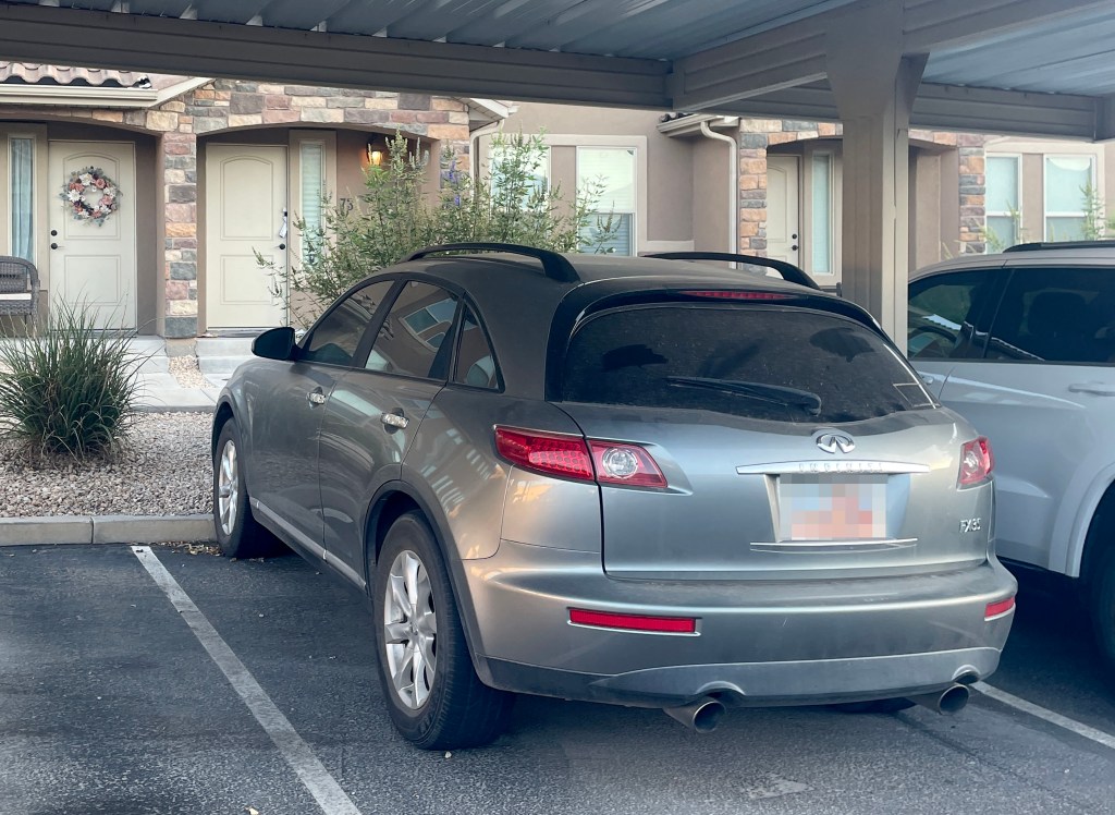 A gray Infiniti FX35 SUV parked under a carport at Lance Twiggs' apartment in St. George, Utah.