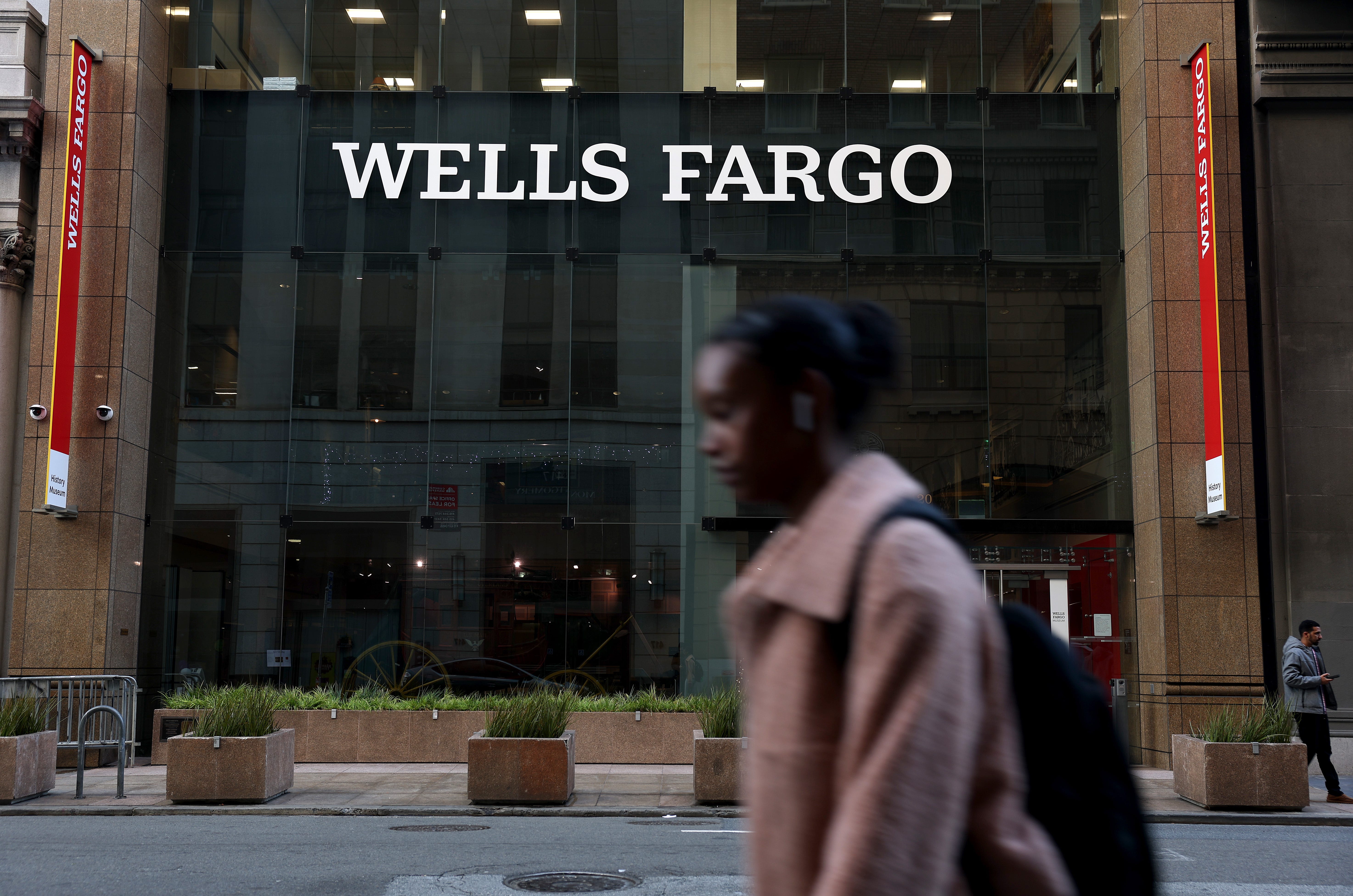A woman walks in front of the Wells Fargo building in San Francisco