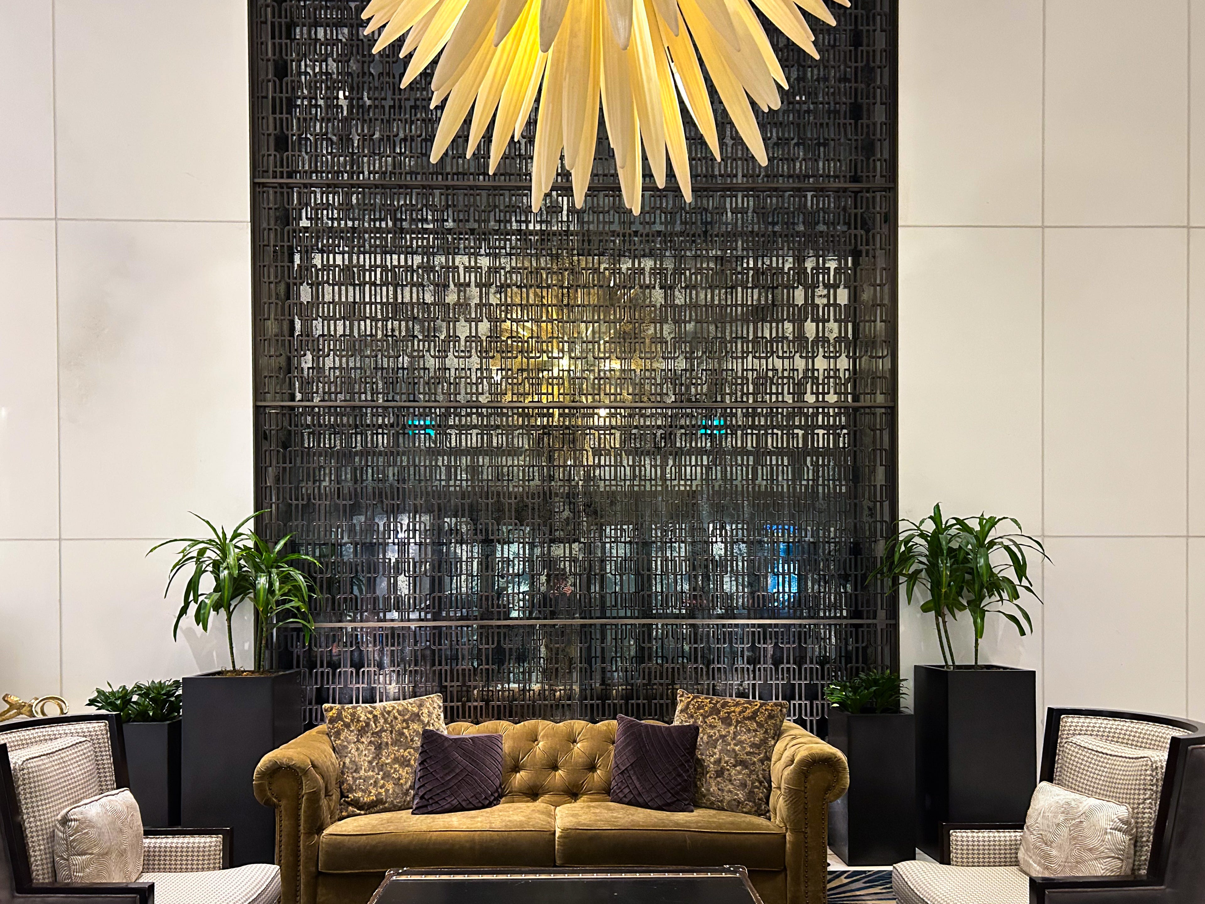 Lufurious furniture, potted plants, and a spiky chandelier in the lobby at the Fairmont Hotel Vancouver