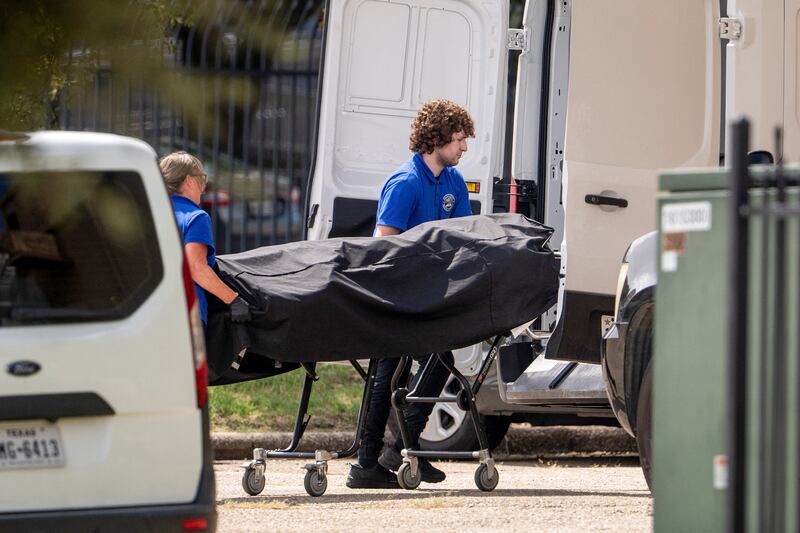 Personnel from the medical examiner's office load the body of the alleged gunman into the back of a van at the scene of a shooting, at an Immigration and Customs Enforcement (ICE) field office in Dallas, Texas, U.S., September 24, 2025.    REUTERS/Jeffrey McWhorter