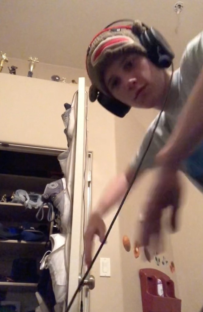 Lance Twiggs wearing headphones and a sock monkey hat.