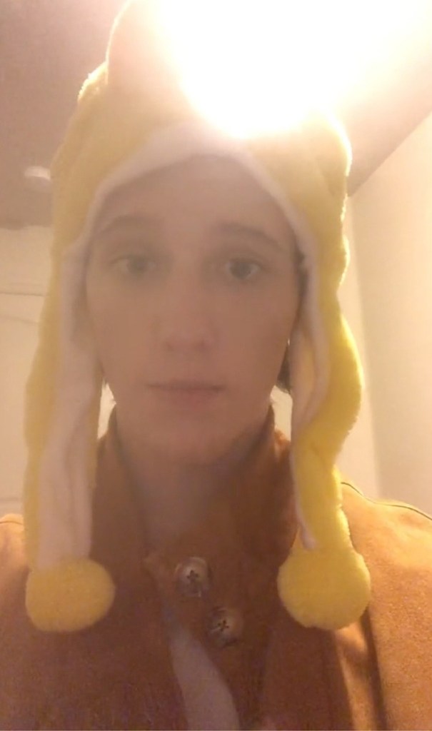 Lance Twiggs wearing a yellow and white hat with ear flaps and pom-poms.