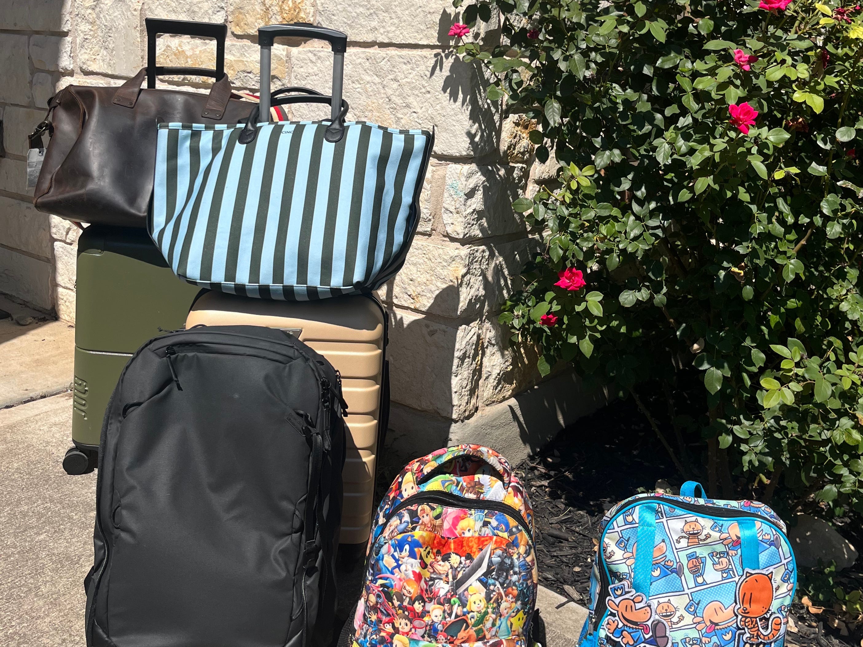 The author's seven carry-ons, which she and her family packed for their monthlong trip to the UK. The bags include three backpacks, two carry-on suitcases, and two duffel bags.