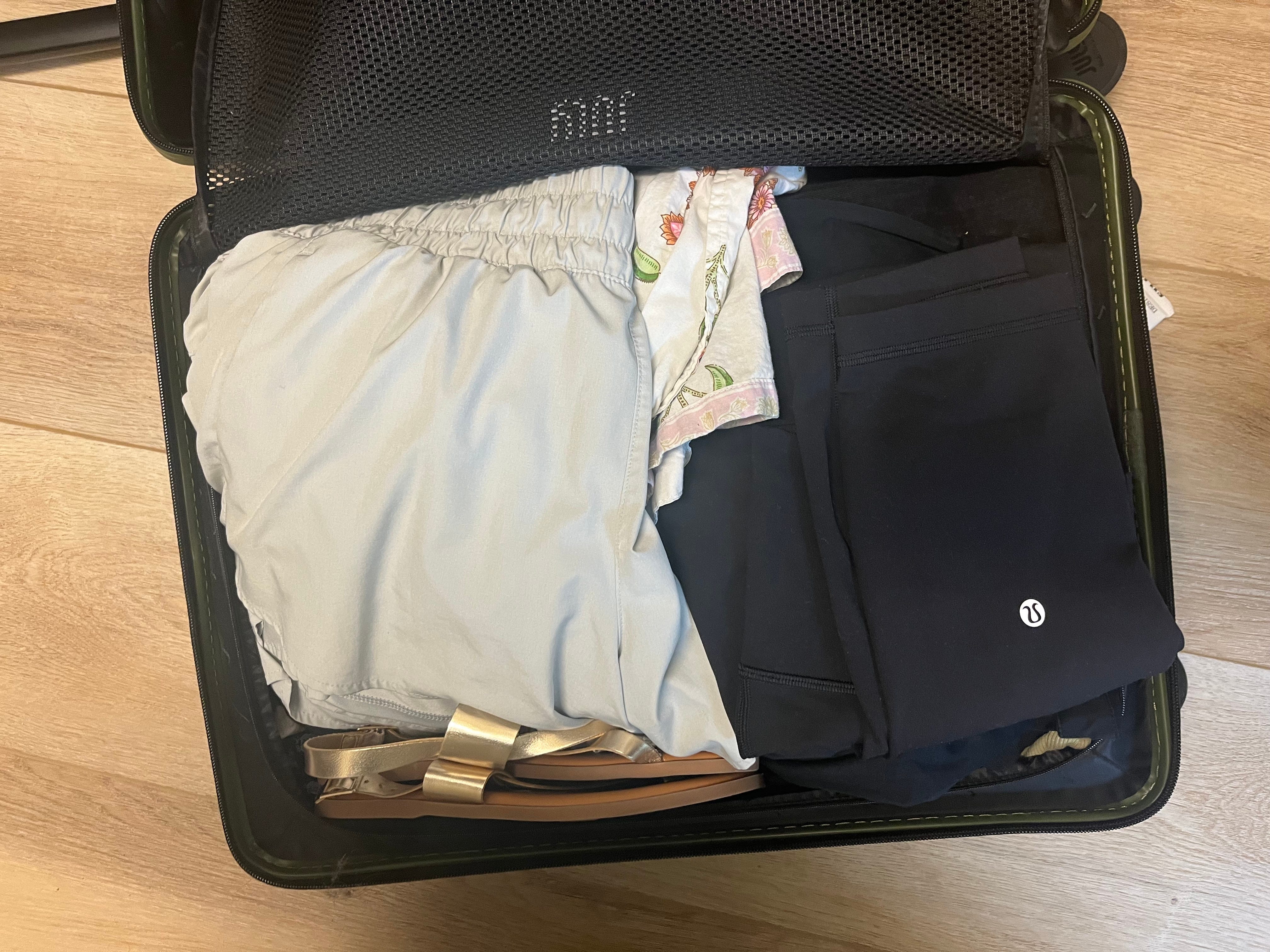 The author's packed suitcase. A pair of shorts and some gold and brown sandals are visible.