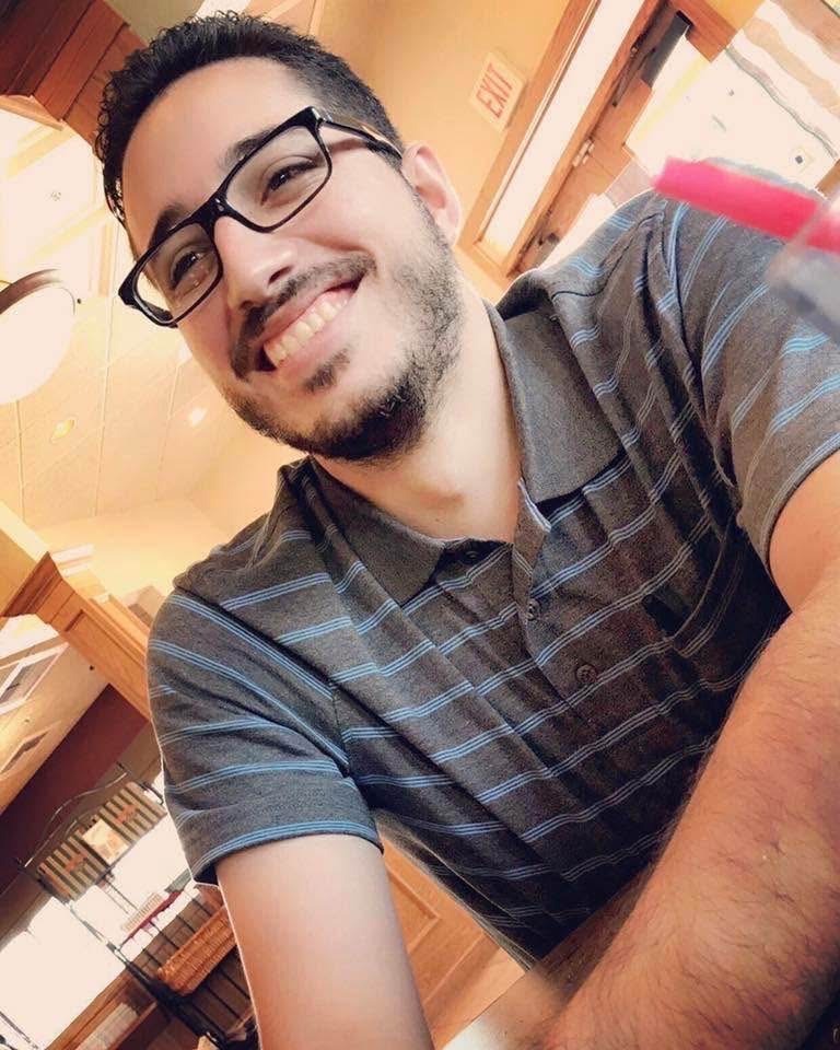 Kevin Rodriguez Zavala smiling and wearing a striped polo shirt and glasses.