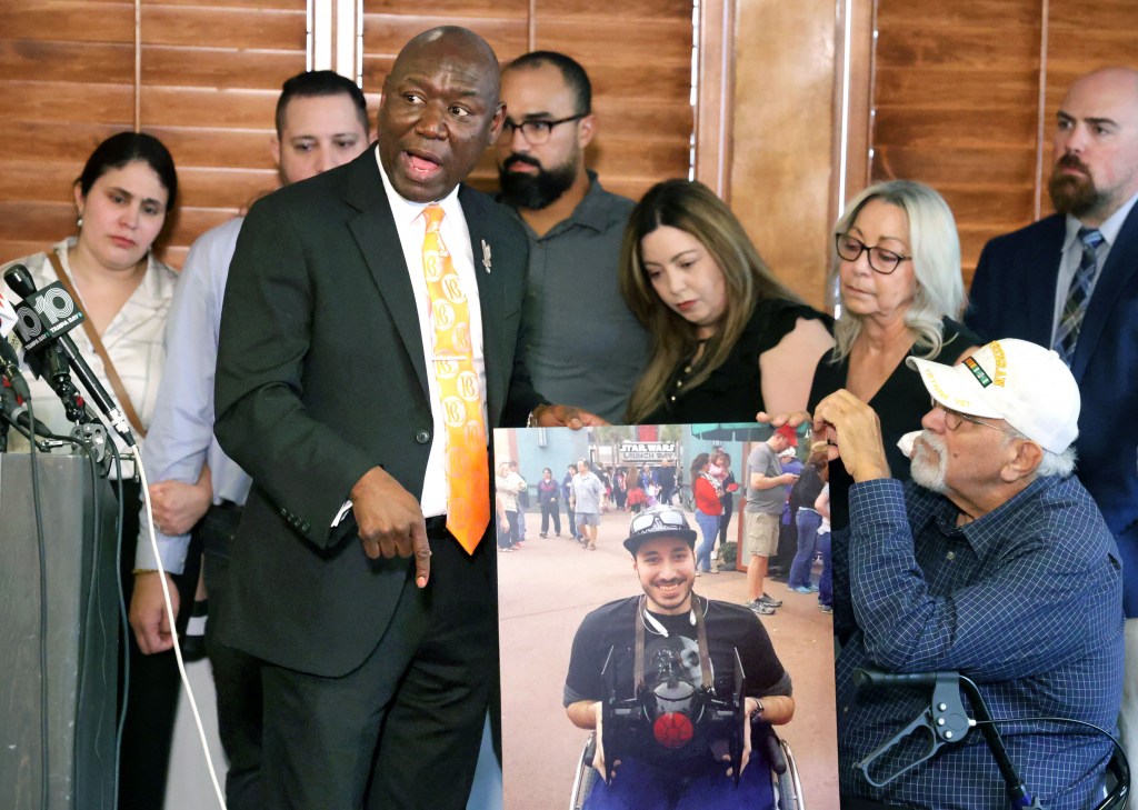 Attorney Benjamin Crump and the family of Kevin Zavala hold a photo of Zavala during a press conference.