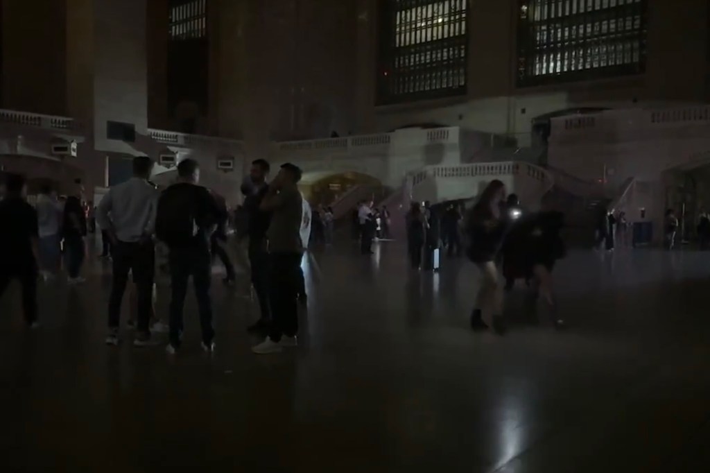 People stand in Grand Central Terminal during a power outage.