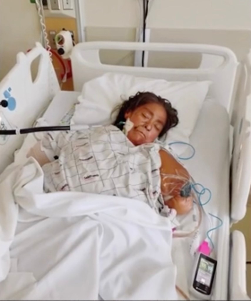 A patient with an oxygen cannula and medical equipment lying in a hospital bed.