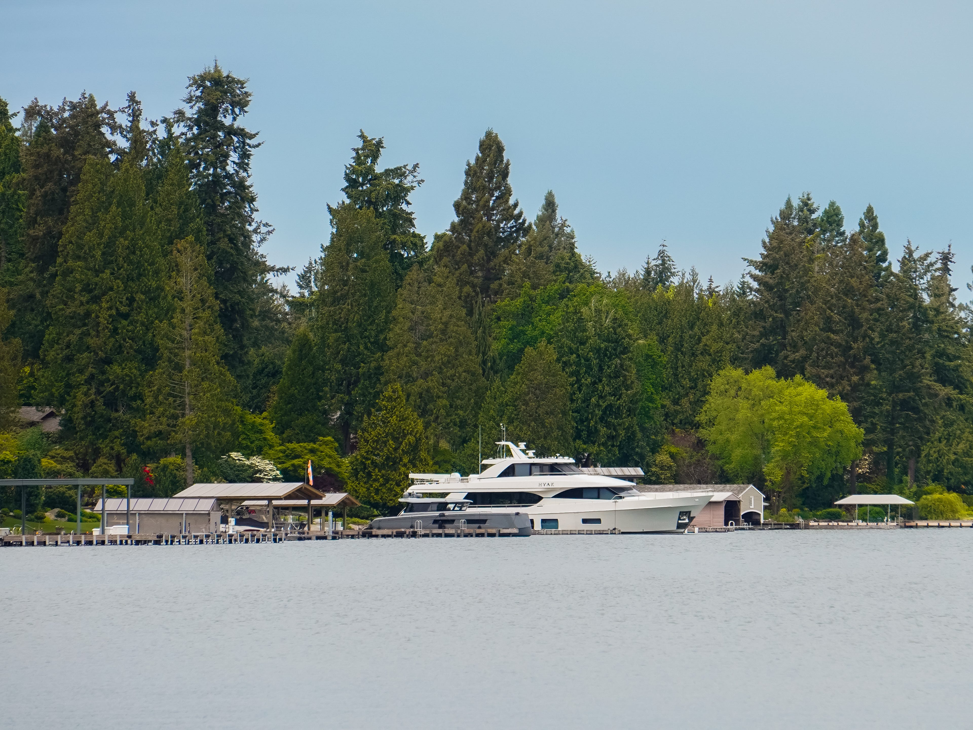 In Medina, Washington, a yacht is docked in a body of water with tall trees in the background