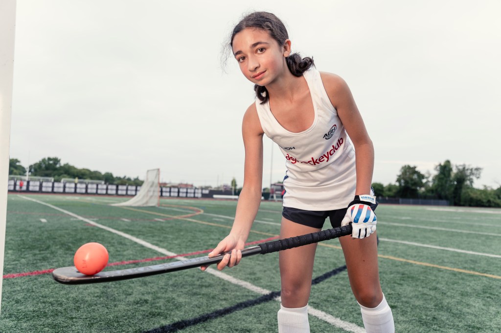Olivia Goncalves, a Garden City field hockey player, on the field with her stick and ball.