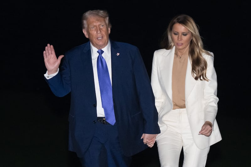 US President Donald Trump and First Lady Melania Trump walk on the South Lawn after disembarking from Marine One