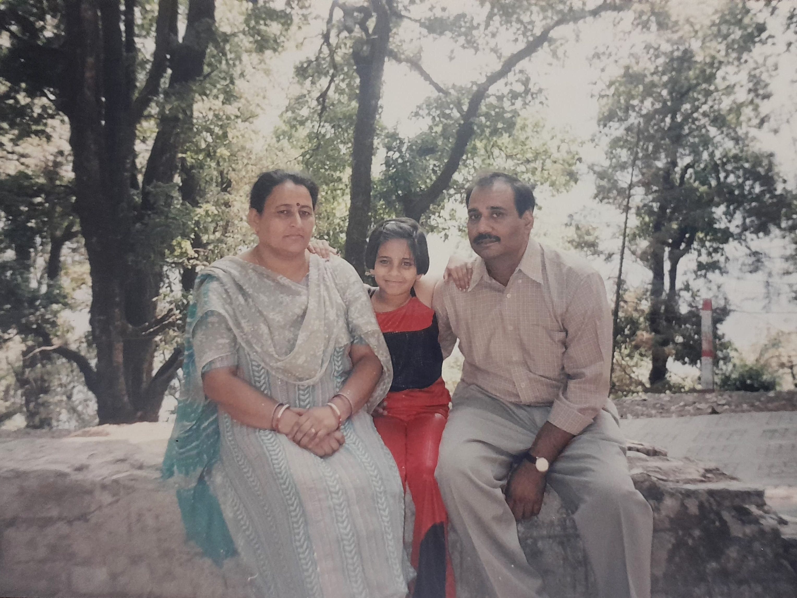 A photo of the author as a child posing with her parents in Manali, India.