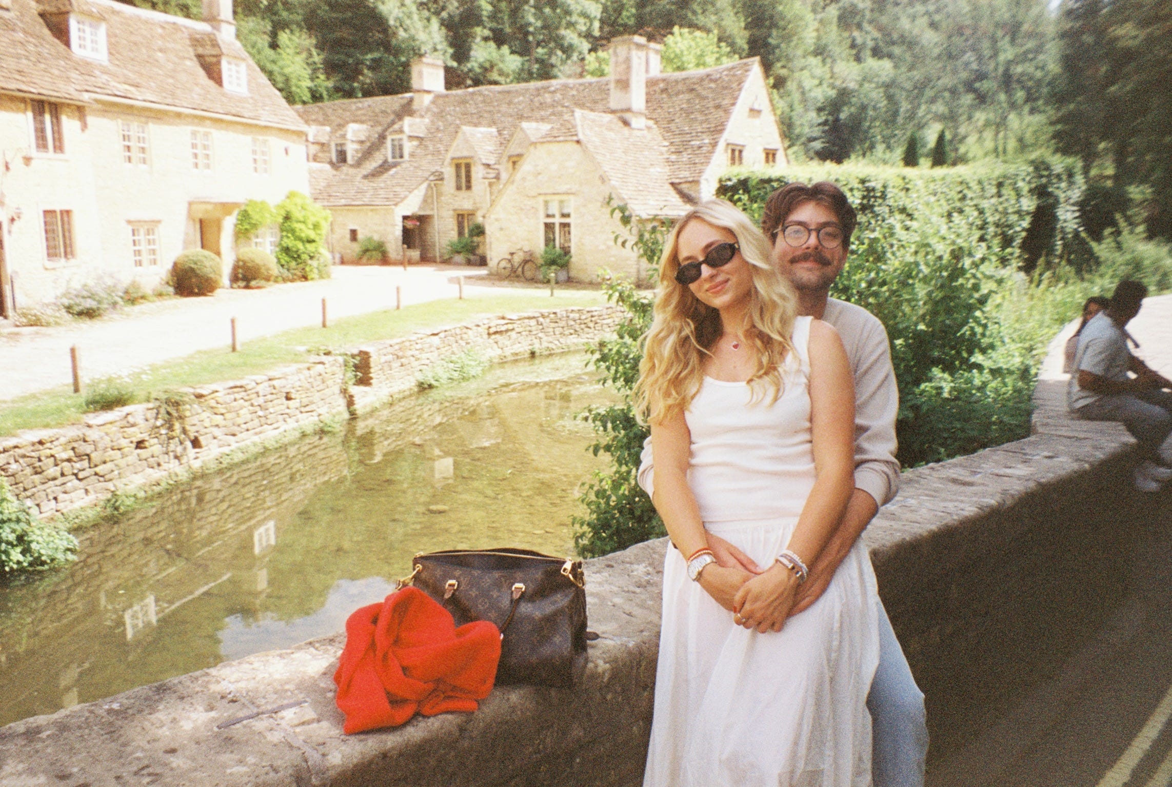 Author Tiana Molony and man smiling sitting on bridge in front of body of water