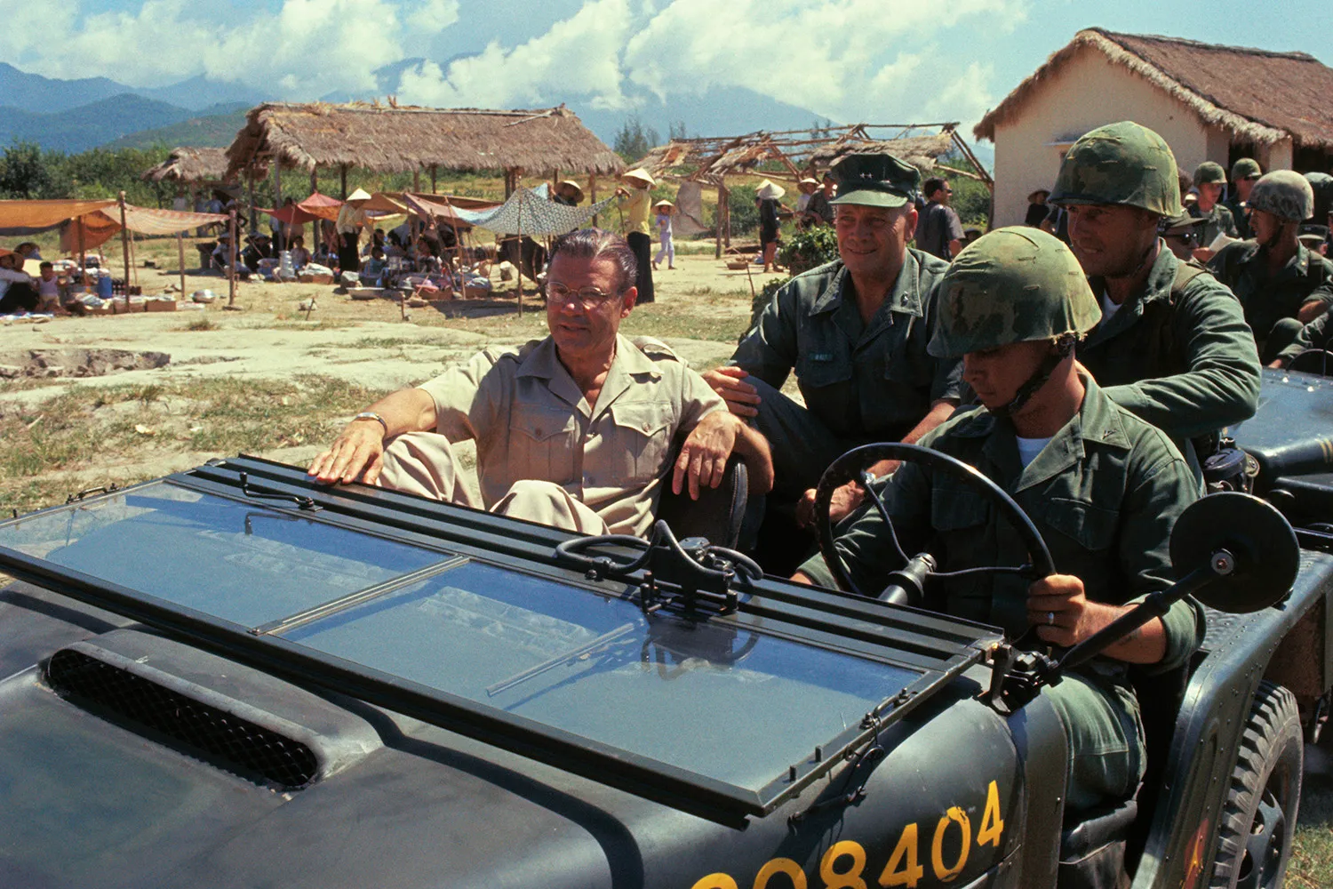 Secretary of Defense Robert McNamara rides in a jeep during a visit to Le My, Vietnam in 1965.