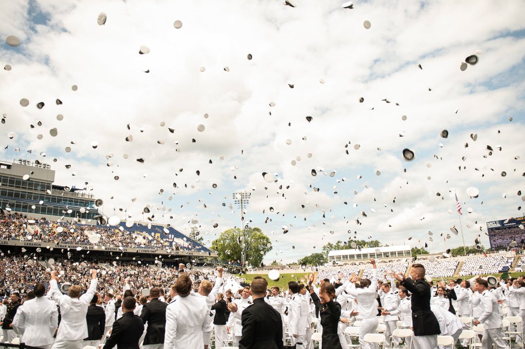 Graduates of the U.S. Naval Academy throw their hats into the air after the graduation ceremony at Navy-Marine Corps Memorial Stadium.