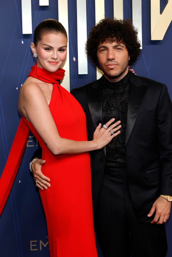 Selena Gomez in a red evening gown, Benny Blanco in a black suit and black shirt and tie.