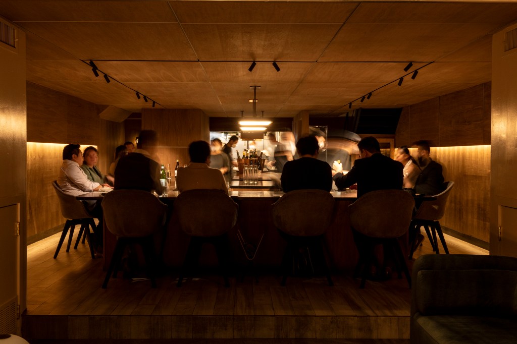 People seated at the bar and tables of Atomix, the critically acclaimed Nomad restaurant.