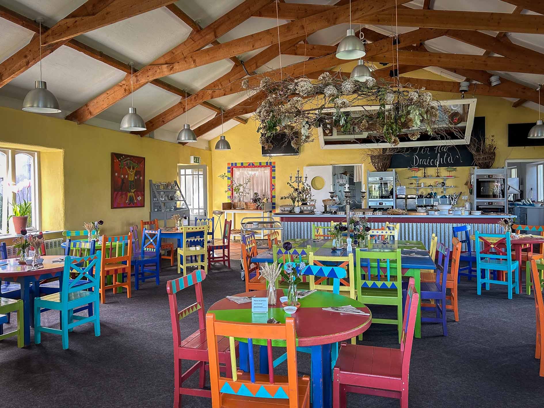 A rustic-looking dining room with colorful tables and chairs.