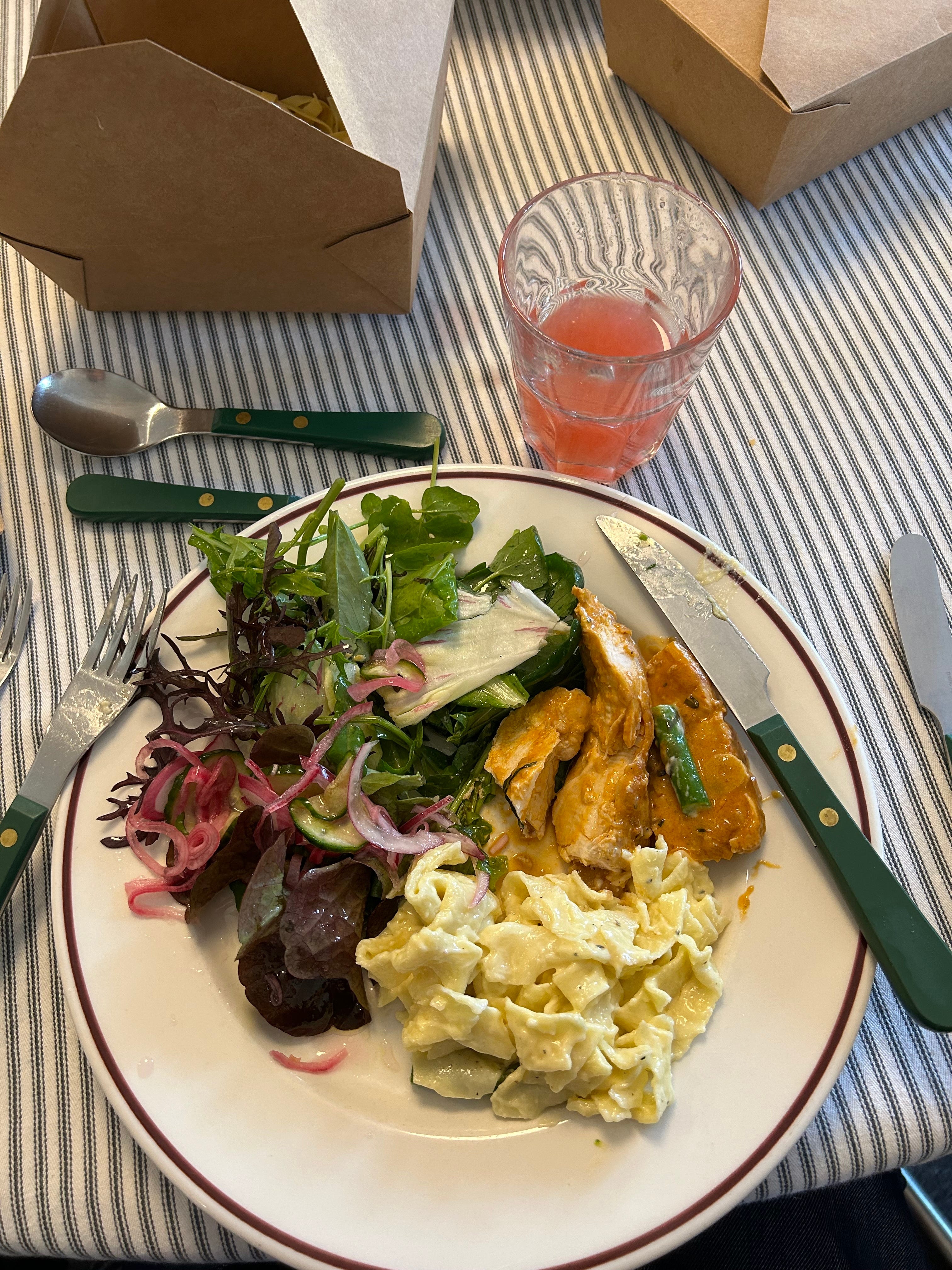 A plate of chicken paprikash, pasta Alfredo, and green salad.