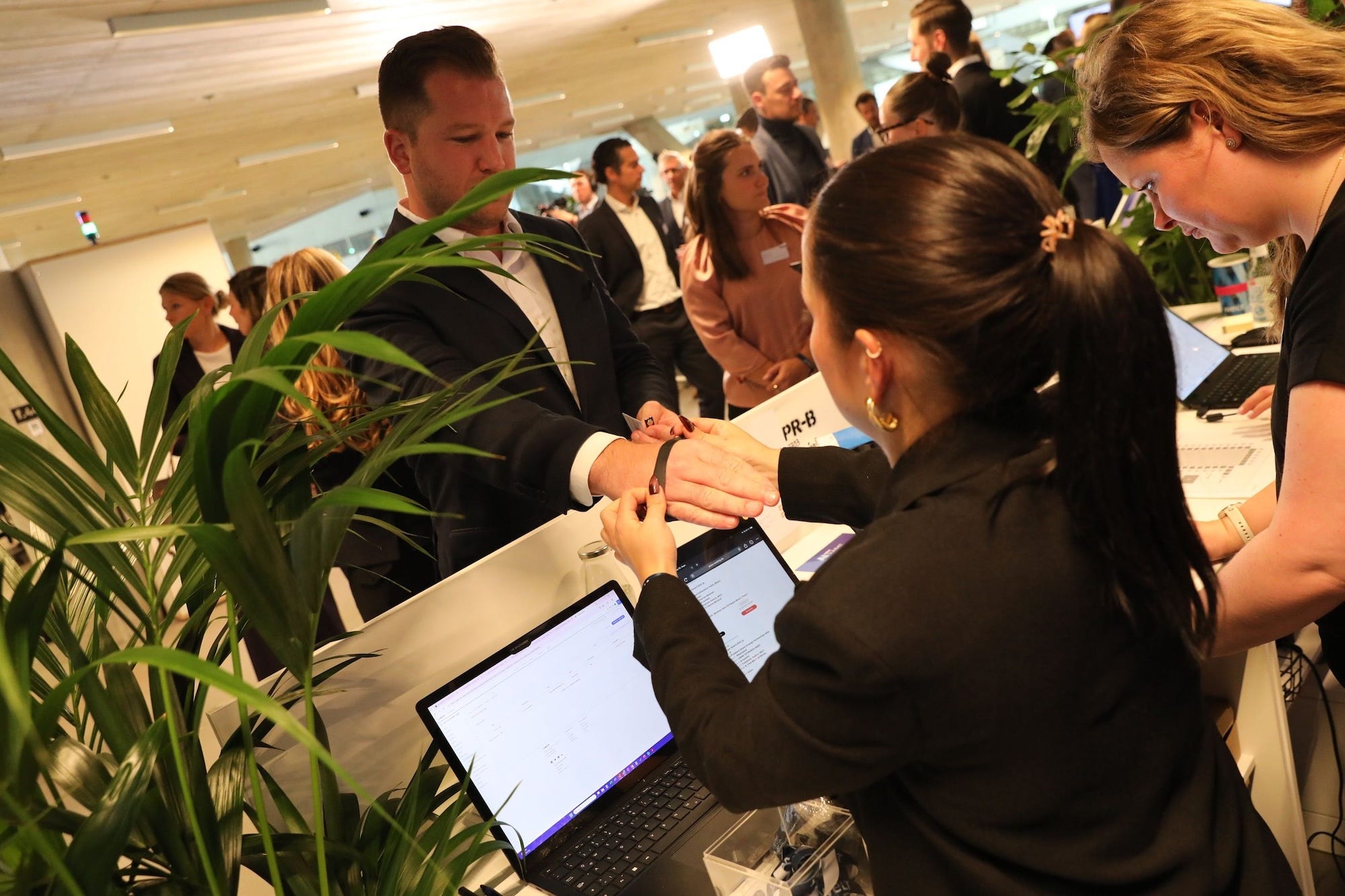 A woman slips a band onto a conferencegoer's wrist.