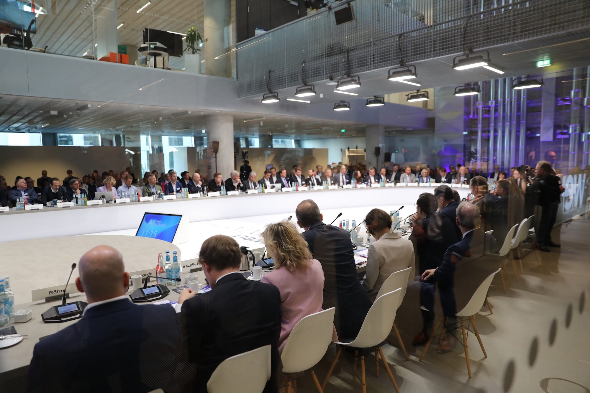 Professionals sit around a U-shaped conference table.