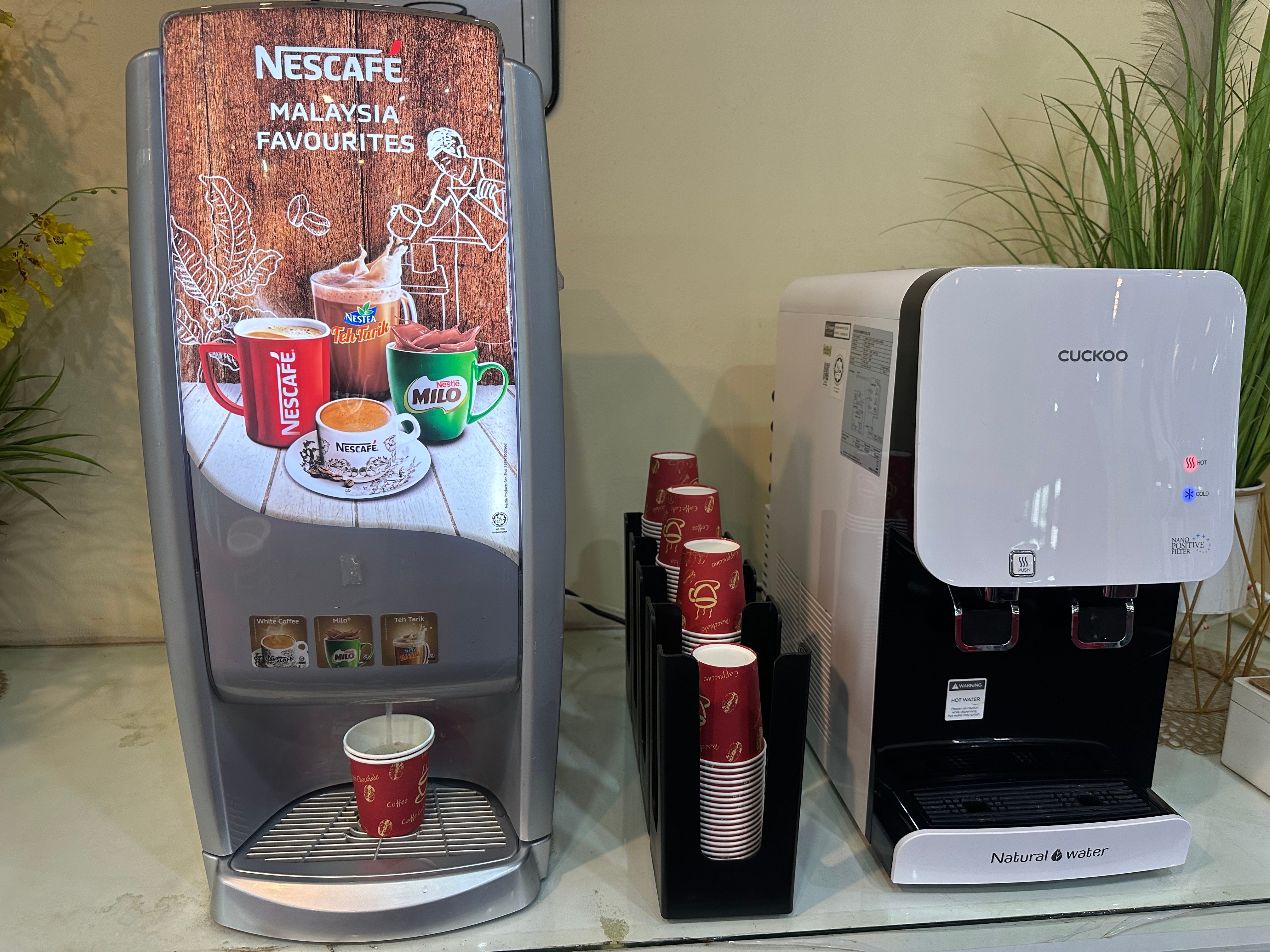 Nescafe machine with cups next to cuckoo water machine