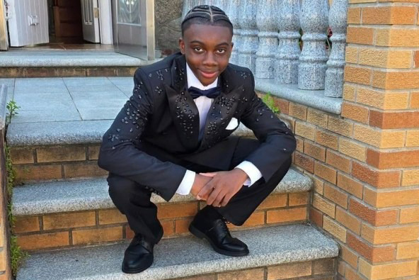 Sanjay Samuel sitting on brick steps.
