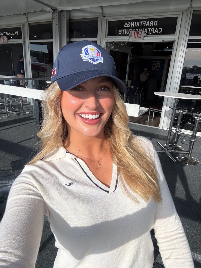 Golf influencer Cailyn Henderson smiling in a Ryder Cup hat.
