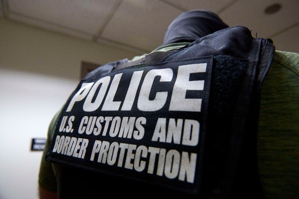 Back of a U.S. Customs and Border Protection officer's vest that says 