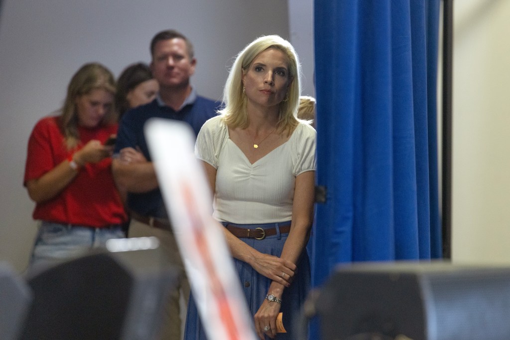 U.S. Rep. Ashley Hinson stands backstage listening to a guest speaker during her BBQ Bash fundraiser in Cedar Rapids, Iowa.