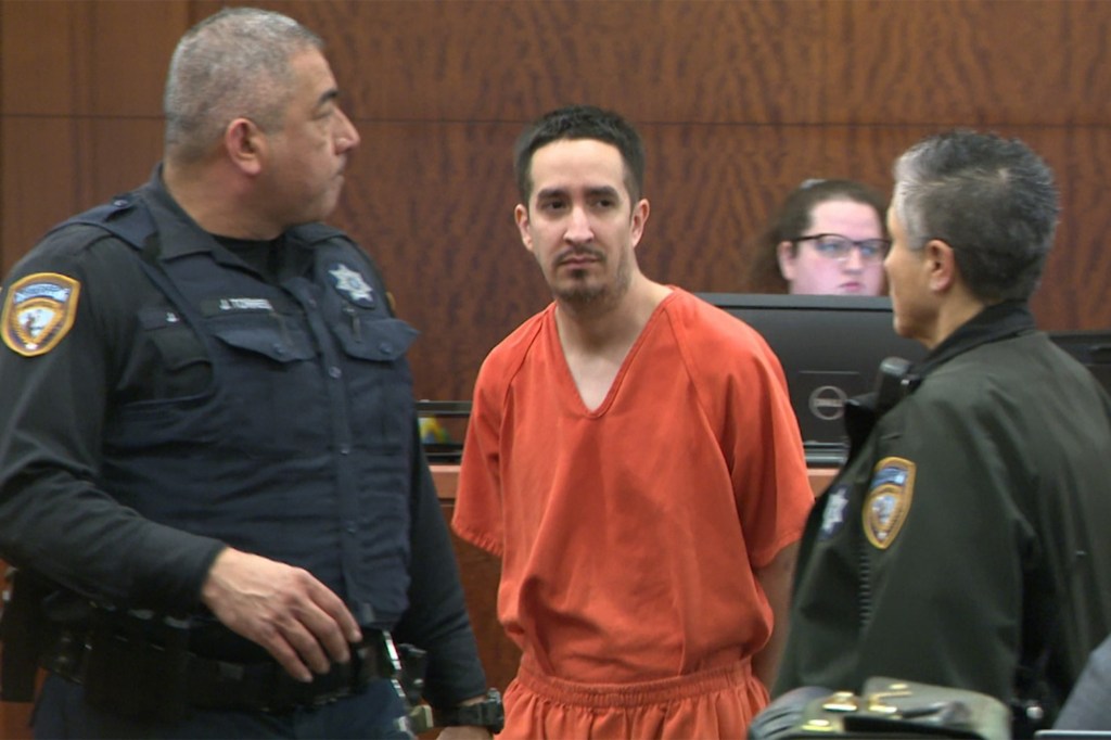 James Paul Anderson in court, flanked by two officers.