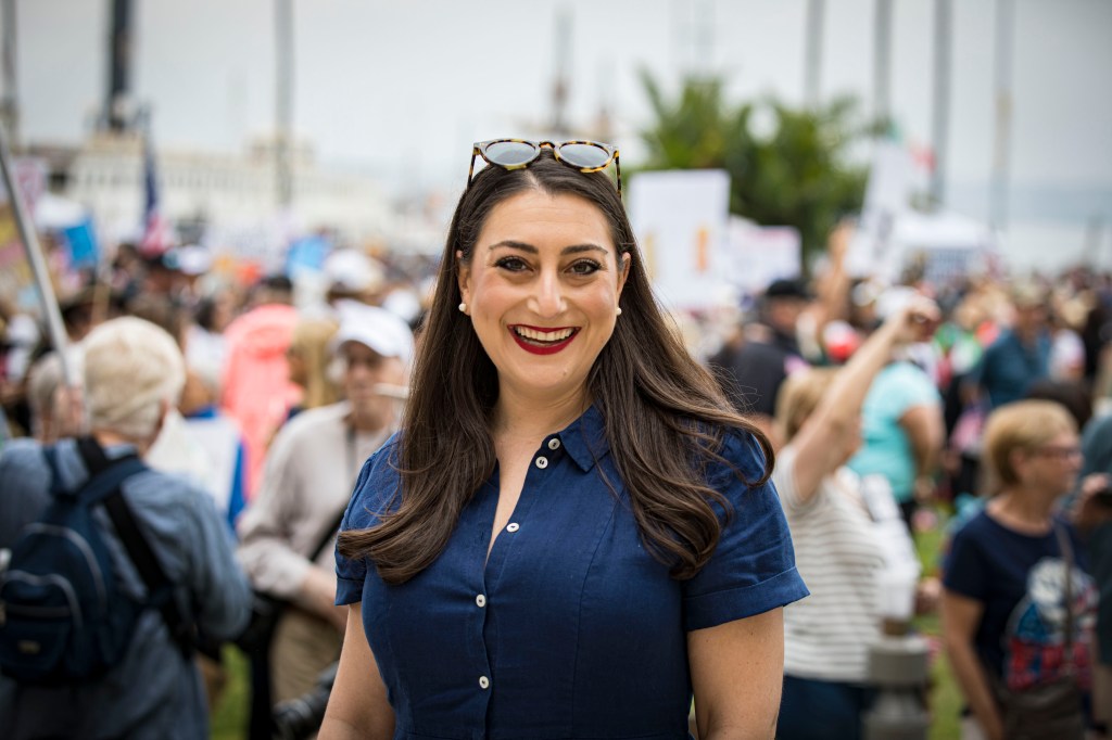 Congresswoman Sara Jacobs smiling at a San Diego protest.