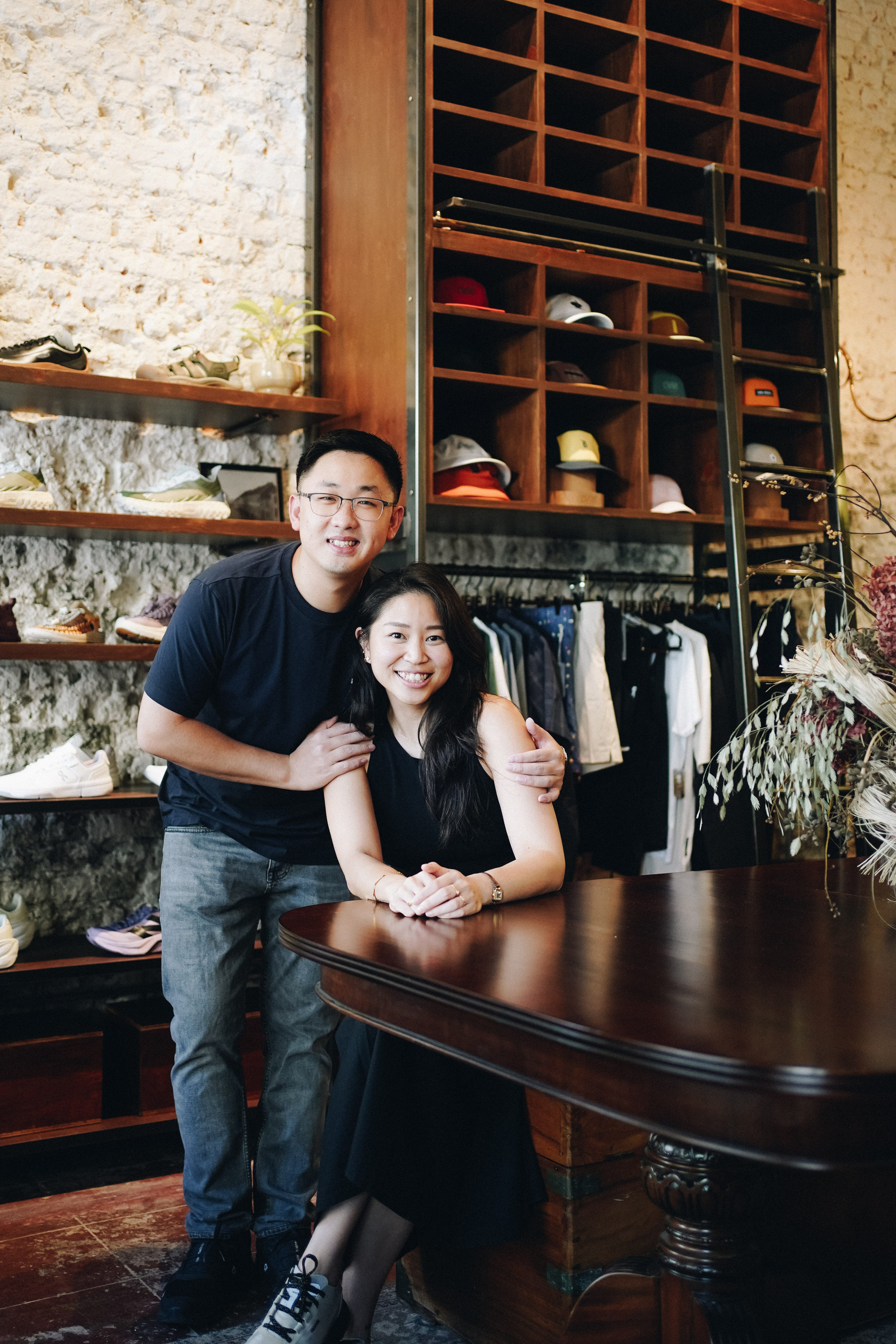 A man and a woman posing in a retail store.