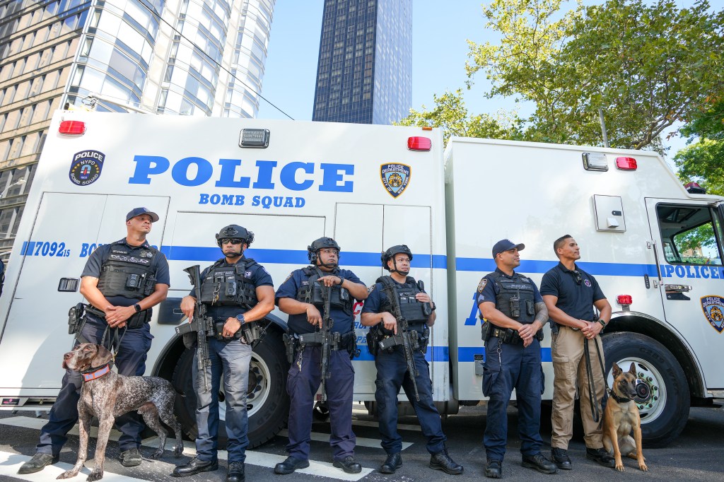 NYPD Bomb Squad officers and K9 unit stand with their vehicle near the UN building.