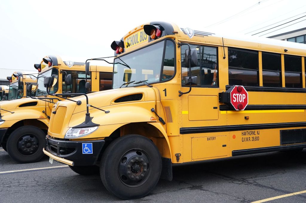 Yellow school buses parked in a high school parking lot in Hawthorne, NJ
