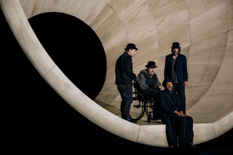 Alex Winter as ‘Vladimir,’ Michael Patrick Thornton as ‘Lucky’ (in wheel chair), Brandon J. Dirden as ‘Pozzo’ (seated on stage), and Keanu Reeves as ‘Estragon.’