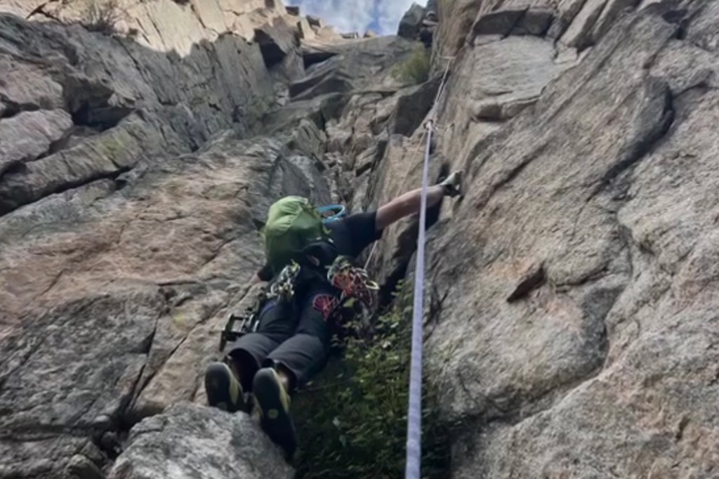 Rock climber ascending a steep rock face.