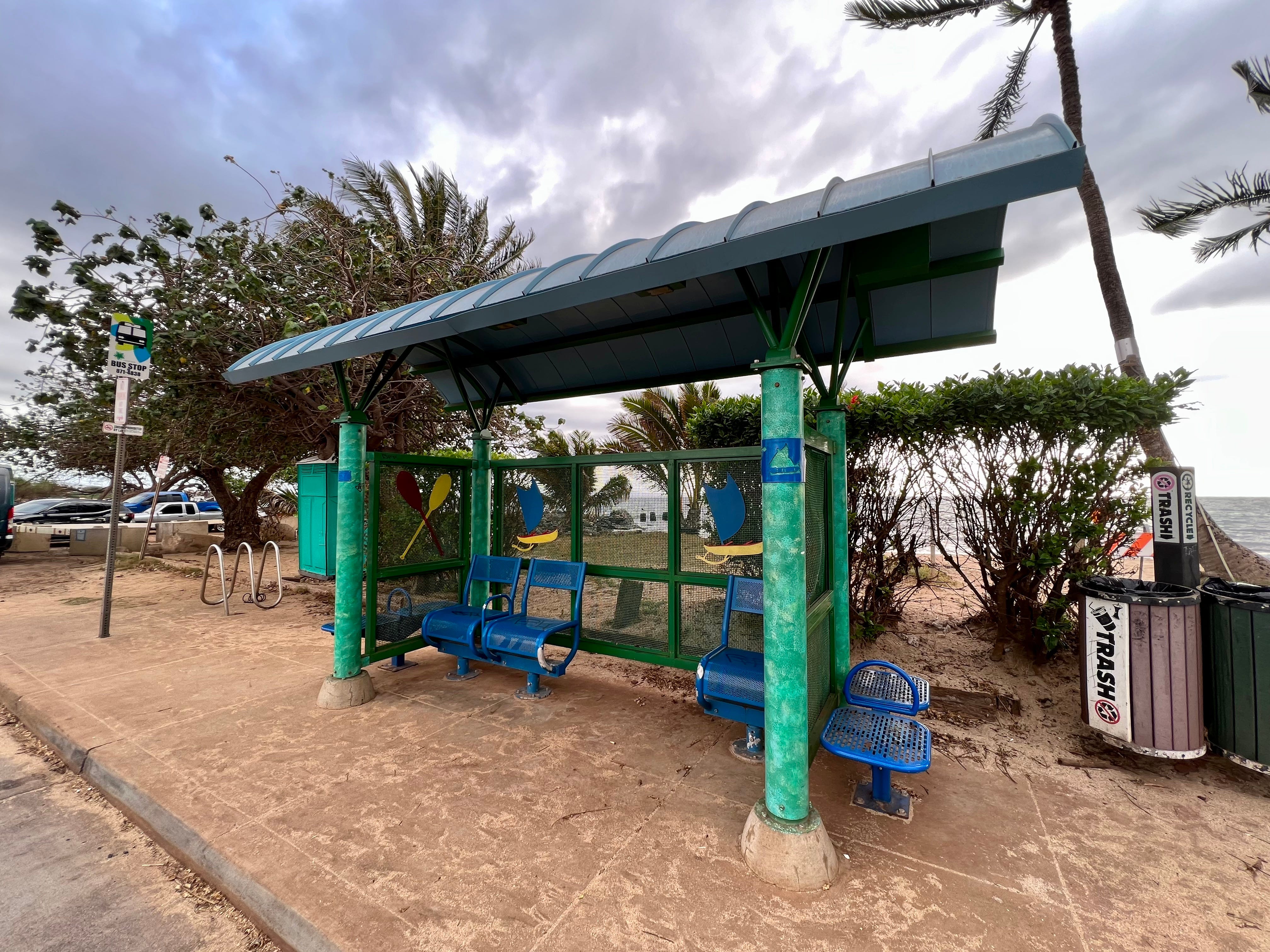 Bus stop in Hawaii with bach behind it