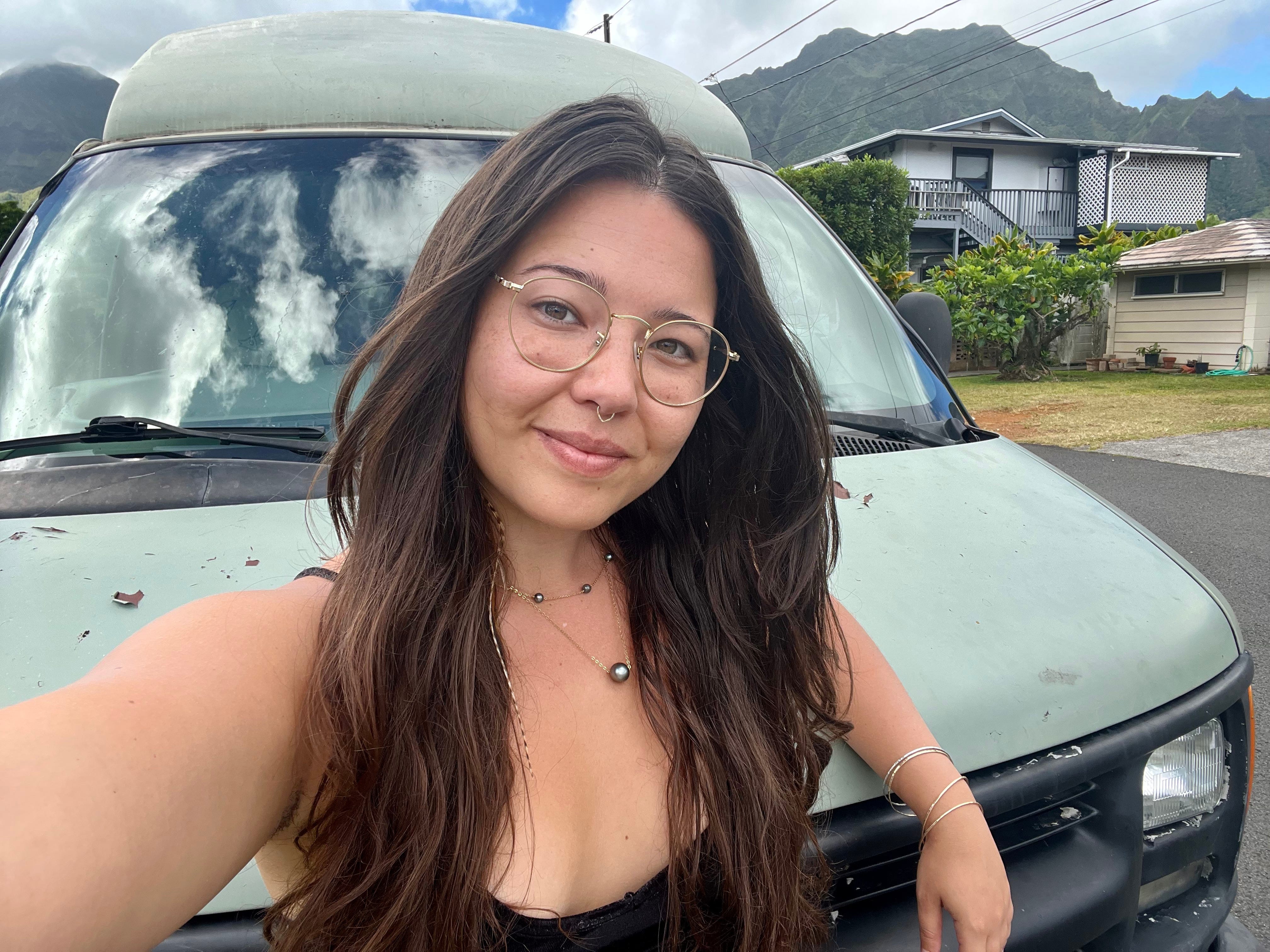 Author Ashley Probst smiling in front of a campervan