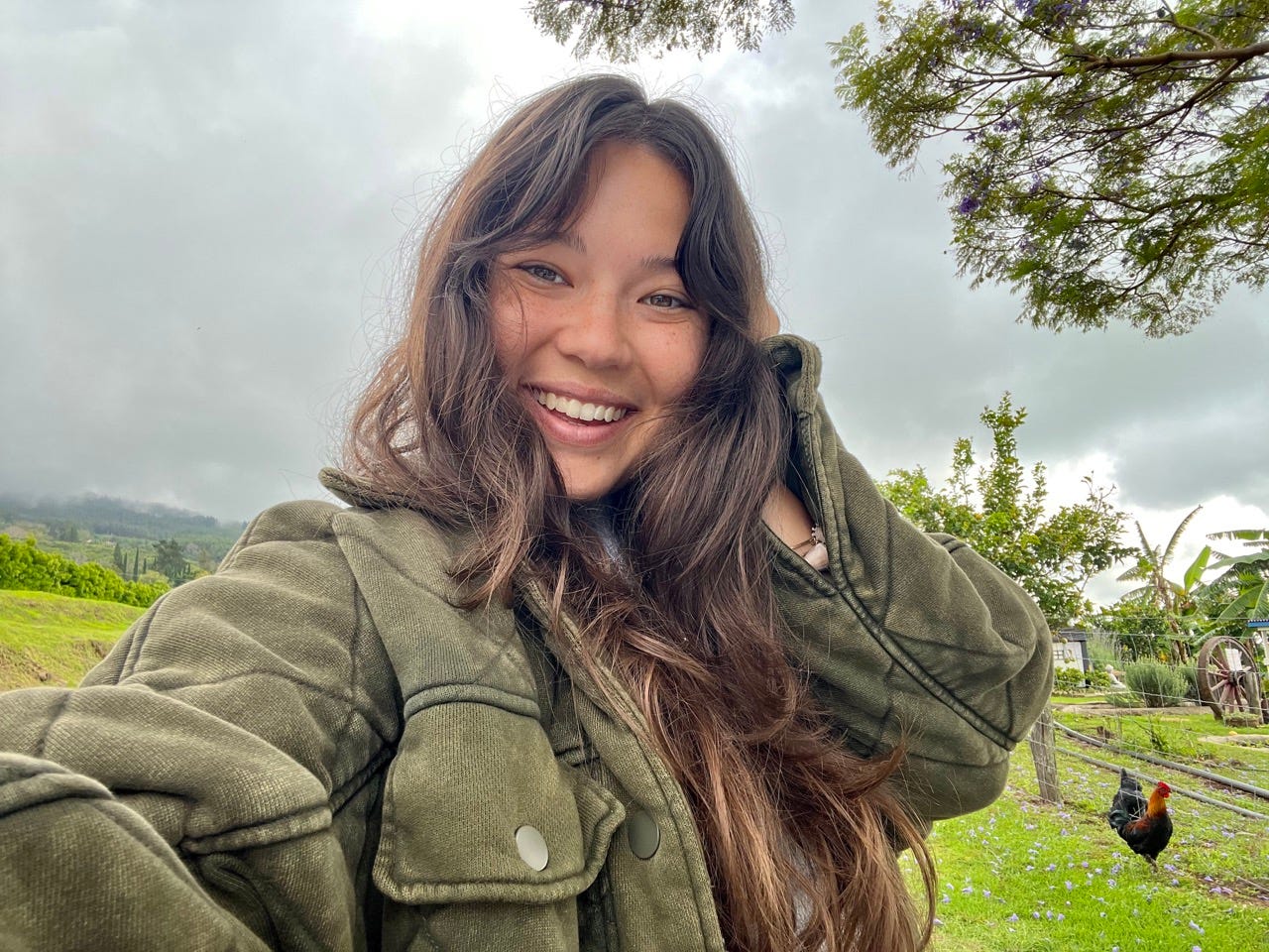 Author Ashley Probst smiling in jacket in front of gray skies in Hawaii