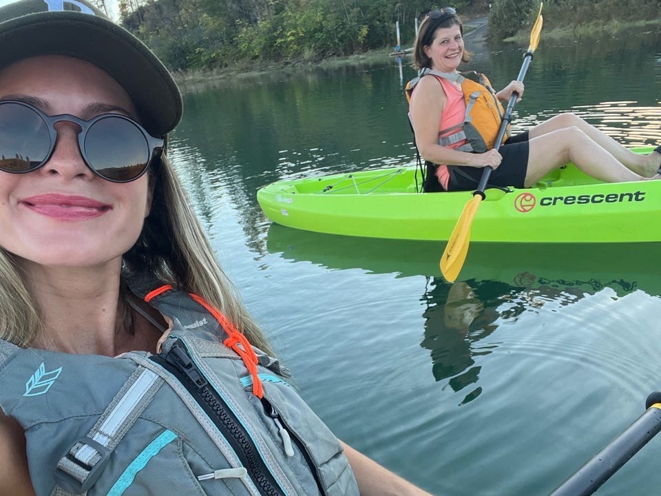 Author Alexa Mellardo and her mom smiling in kayaks