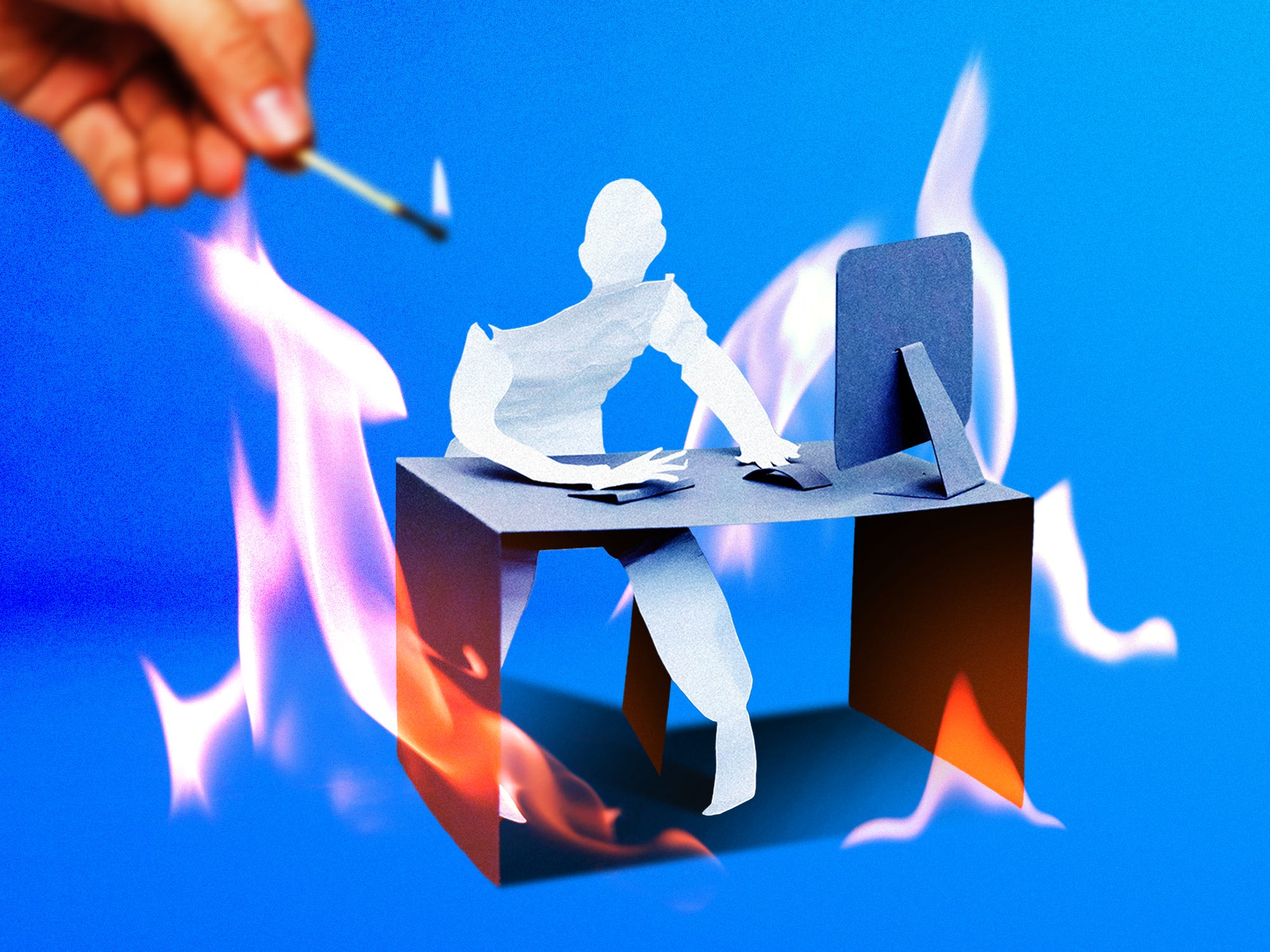 A paper figure and desk being lit on fire