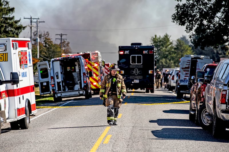 GRAND BLANC, MICHIGAN - SEPTEMBER 28: A firefighter walks down the street where emergency services are responding to a shooting and fire at the Church of Jesus Christ of Latter-day Saints on September 28, 2025 in Grand Blanc, Michigan. According to police reports there are multiple victims and the shooter is down. (Photo by Emily Elconin/Getty Images)