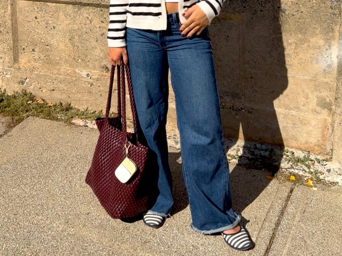 A close-up of Amanda's blue jeans and striped shoes.