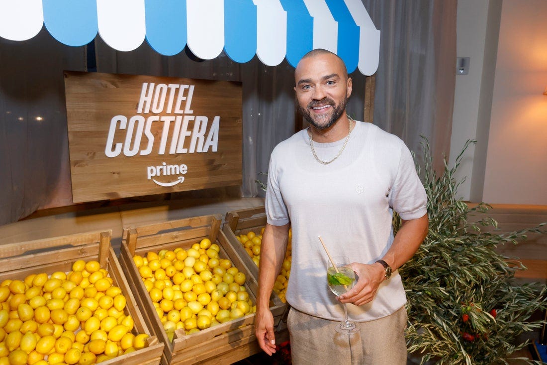Jesse Williams holding a drink.