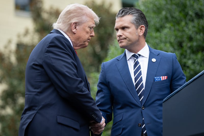 Donald Trump greets Pete Hegseth (R) during a September 11th observance event in the courtyard of the Pentagon September 11, 2025 in Arlington, Virginia.