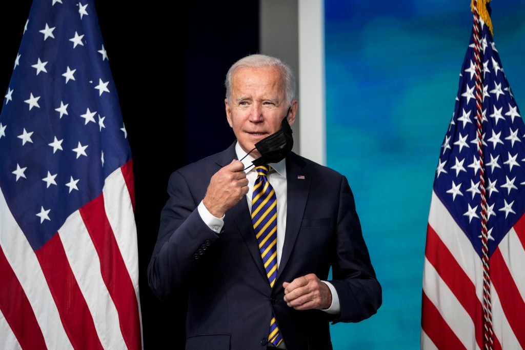 President Joe Biden removes his face mask while speaking about the coronavirus pandemic.