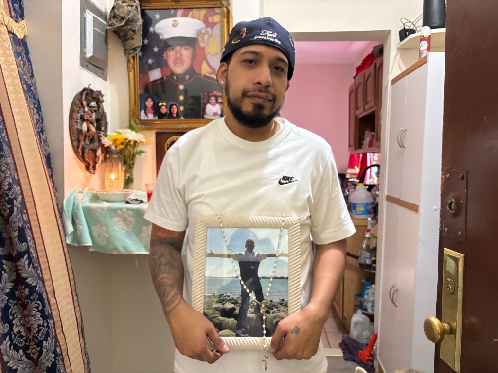 Henry Hernandez holding a picture of his father.
